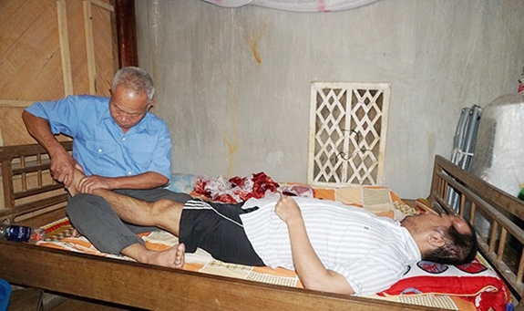 Ông Trần Văn Sơn chăm sóc con trai nằm một chỗ.